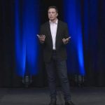 Elon Musk presenting on stage.
