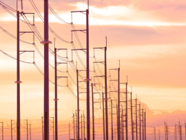 Silhouette row of electric poles against orange cloud with golden sunlight on sunset sky background